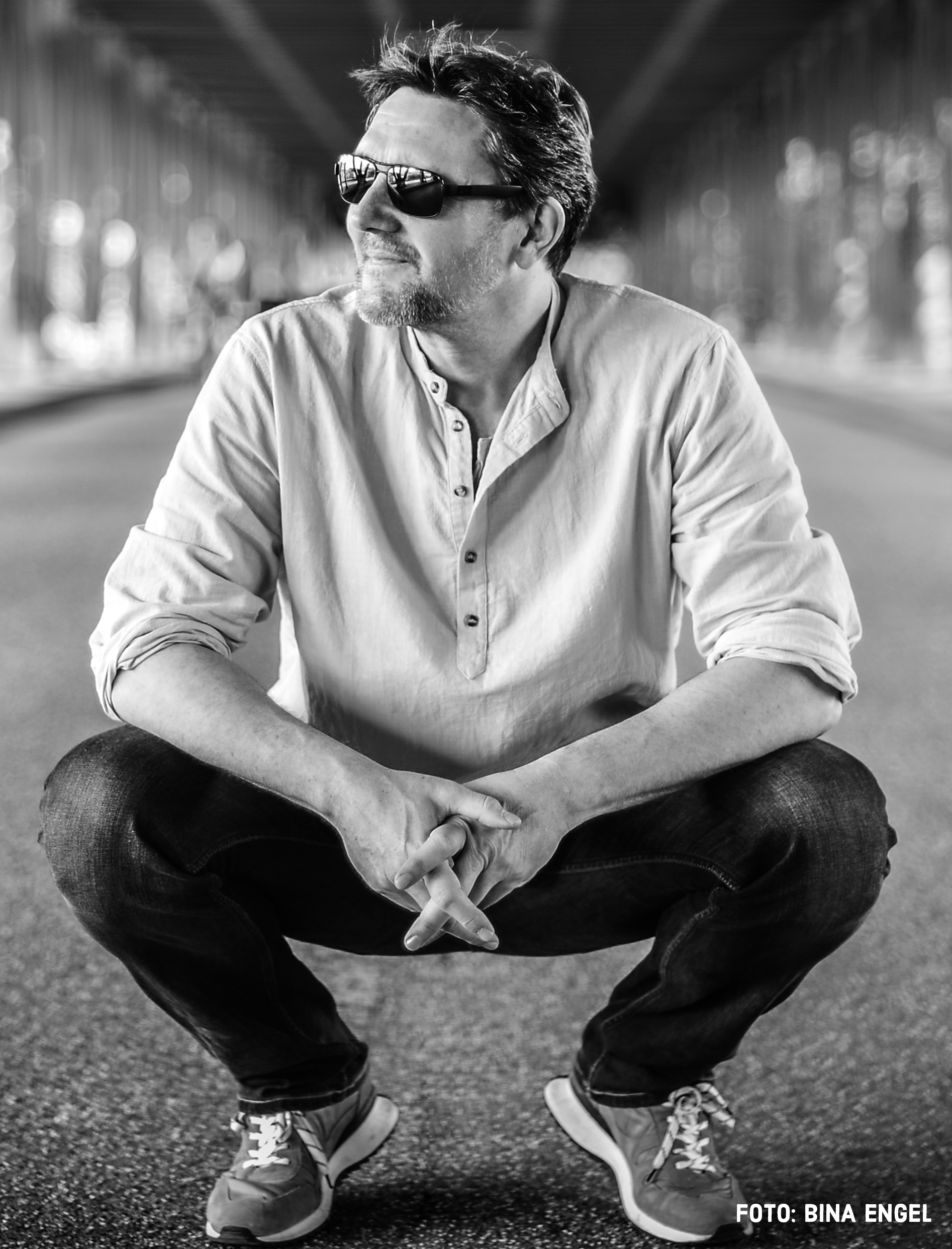 Tony Tonagel im Ganzkörperportrait, stehend in schwarz-weißem Stil